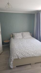 a bedroom with a bed with a white comforter at Maisonnette 6 personnes en Auvergne à Saint Remy sur Durolle 