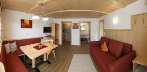 ein Wohnzimmer mit einem roten Sofa und einem Tisch in der Unterkunft Ferienhof Auerhof in Walchsee