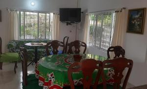 una sala da pranzo con tavolo, sedie e TV di Finca El Jardin SOLO PARA FAMILIAS a Tocaima