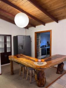 Una cocina con una mesa de madera y un refrigerador. en Cabañas Pucontours, en Pucón