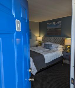 a bedroom with a bed and a blue door at Huron Inn in Saint Ignace
