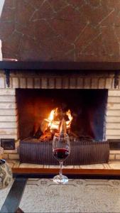 a glass of wine in front of a fireplace at Casa Goldoni Gramado in Gramado