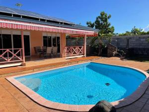 une grande piscine bleue en face d'une maison dans l'établissement TAHITI - Fare Vairai Pool, à Fa'a'ā