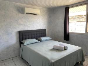Un dormitorio con una cama con una almohada encima. en TAHITI - Fare Vairai Pool, en Faaa 15 fotos más