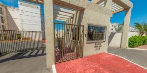 a gate on a building with a red carpet at Apto Solar do Coqueiro in Campos dos Goytacazes