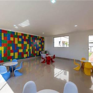 a room with tables and chairs and a colorful wall at Apto Solar do Coqueiro in Campos dos Goytacazes