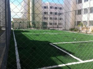 a tennis court with a fence in front of a building at Apto Solar do Coqueiro in Campos dos Goytacazes +4 photos