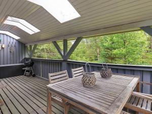 una mesa de madera y sillas en una terraza de madera en 5 person holiday home in lb k, en Ålbæk