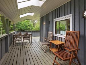 un porche cubierto con mesa y sillas en 5 person holiday home in lb k, en Ålbæk
