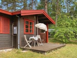 een kleine hut met een tafel en stoelen op een terras bij Holiday home Store Fuglede XXI in Store Fuglede