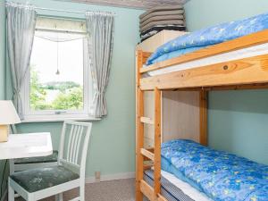 a bedroom with bunk beds with a desk and a chair at Holiday home Ebeltoft CXCIV in Ebeltoft