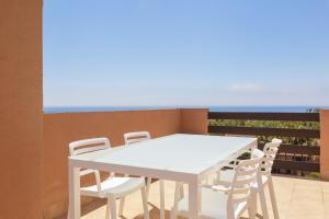 a white table and chairs on a balcony with the ocean at Fresh penthouse apartment with great sea views in Casares