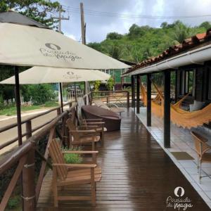 a patio with chairs and umbrellas on a deck at Pousada da Maga in Fernando de Noronha