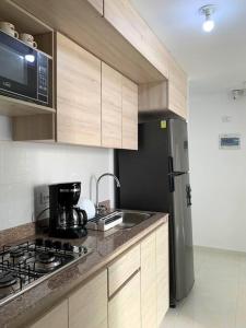 ペレイラにあるEspectacular apartamento completo en Pereiraのキッチン(コンロ、冷蔵庫付)