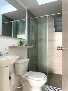 a bathroom with a toilet and a glass shower at Espectacular apartamento completo en Pereira in Pereira