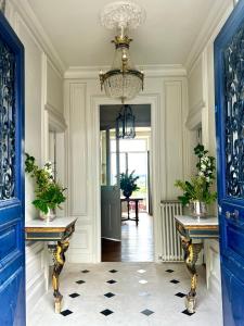 a hallway with a blue door and a chandelier at Maison Loire in Blois