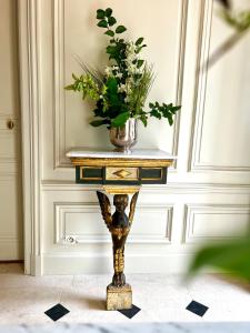 a console table with a vase of flowers on it at Maison Loire in Blois