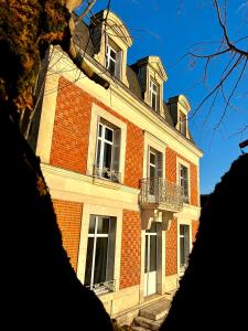 a large brick building with windows and a balcony at Maison Loire in Blois