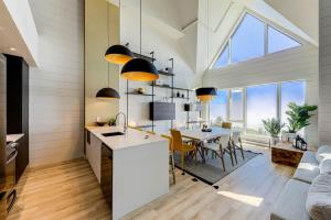 a kitchen and dining room with a table and chairs at Les Immeubles Charlevoix 750-409 in Baie-Saint-Paul