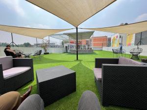 a rooftop patio with chairs and tables and grass at Downtown Treasure Place in Mexico City