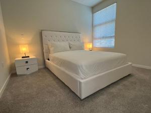 a bedroom with a large white bed with two lamps at ViewPoint Suites in Los Angeles