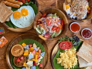 a wooden table with plates of food on it at Gord ChiangMai - SHA Extra Plus in Chiang Mai