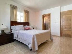 um quarto com uma cama grande e uma janela em Casa Familiar en el Valle de Constanza em Constanza