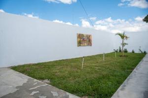 Una pared blanca con un cuadro. en Casa Familiar en el Valle de Constanza, en Constanza