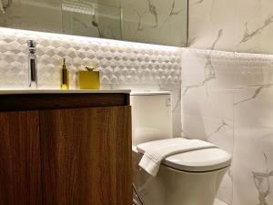 a white bathroom with a toilet and a sink at The Litton Hotel by Carterson in Naga