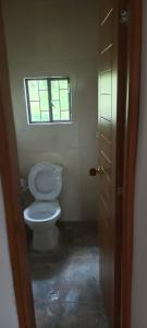 a bathroom with a toilet and a window at Cabaña Eliseo Guachato Villa Rosita in Tota