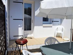 een patio met een tafel, een stoel en een parasol bij Maison La Tranche-sur-Mer, 2 pièces, 4 personnes - FR-1-22-244 in La Tranche-sur-Mer