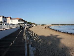 een strand met een hek en mensen op het strand bij Maison La Tranche-sur-Mer, 2 pièces, 4 personnes - FR-1-22-244 in La Tranche-sur-Mer