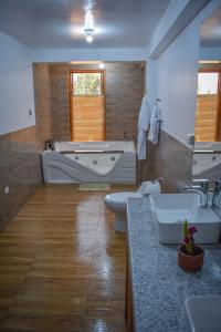 a bathroom with two sinks and a bathtub and a bath tub at CASA TALIOS in Carhuaz