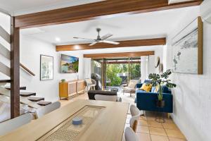 a dining room and living room with a table and chairs at Stylish Townhouse, private courtyard walk to beach in Noosaville