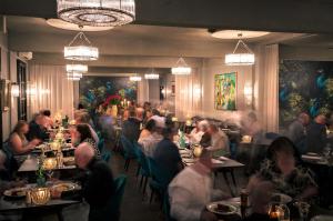 un grupo de personas sentadas en mesas en un restaurante en The Oriana Orange - Retro Hotel & Resort en Orange