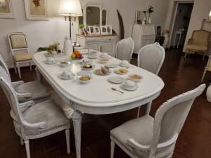 a white dining room table with chairs and food on it at White House - Hospedaje con Desayuno in La Rioja