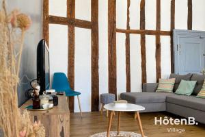 a living room with a couch and a tv at T3 Duplex charme de l'ancien - coeur de ville in Limoges
