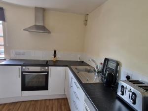 uma cozinha com um lavatório e um fogão em Maidstone Heights III - 1 bedroom in Maidstone! em Maidstone