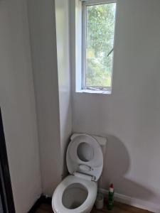 uma pequena casa de banho com WC e janela em Maidstone Heights III - 1 bedroom in Maidstone! em Maidstone