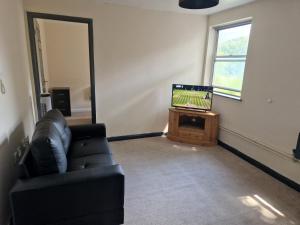 a living room with a couch and a television at Maidstone Heights III - 1 bedroom in Maidstone! in Maidstone