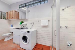 ein Badezimmer mit einer Waschmaschine und einem WC in der Unterkunft KOZYGURU Campsie Oldie-but-goodie look 4 Bed House NCA011 in Sydney