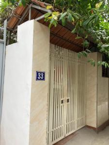 a building with a gate with a blue sign on it at Căn hộ tầng 4 thang bộ đầy đủ tiện nghi, giá rẻ in Hanoi +4 photos