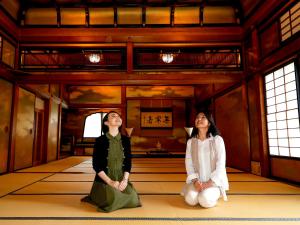 two women sitting on the floor of a room at Hotel Chourakukan Kyoto Gion 長楽館 京都 in Kyoto