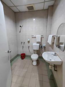 y baño con aseo y lavamanos. en Century Hotel Inanam en Kota Kinabalu