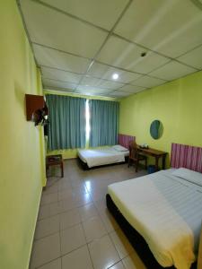 a hotel room with two beds and a table at Century Hotel Inanam in Kota Kinabalu