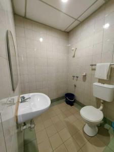 a bathroom with a white toilet and a sink at Century Hotel Inanam in Kota Kinabalu