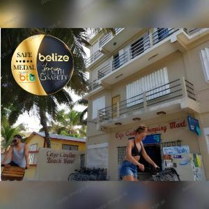 a woman standing in front of a building at Caye Caulker Beach Hotel in Caye Caulker