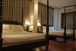 Hotel Veneto De Vigan في فيغان: غرفة نوم بسريرين ومصباحين