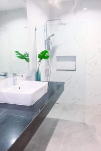 baño con lavabo y jarrón con planta en Be19th Pool Villa, en Cha Am 11 fotos más