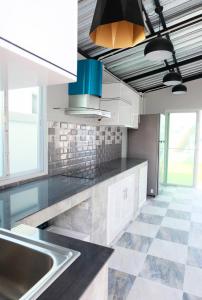 cocina con armarios blancos y suelo de baldosa en Be19th Pool Villa, en Cha Am